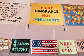 A series of colorful banners hanging from the ceiling in a gallery space