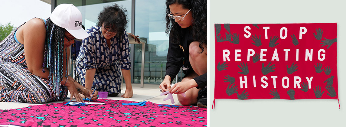 Three people kneeling down over a banner outside next to a hanging banner that says, "Stop Repeating History"