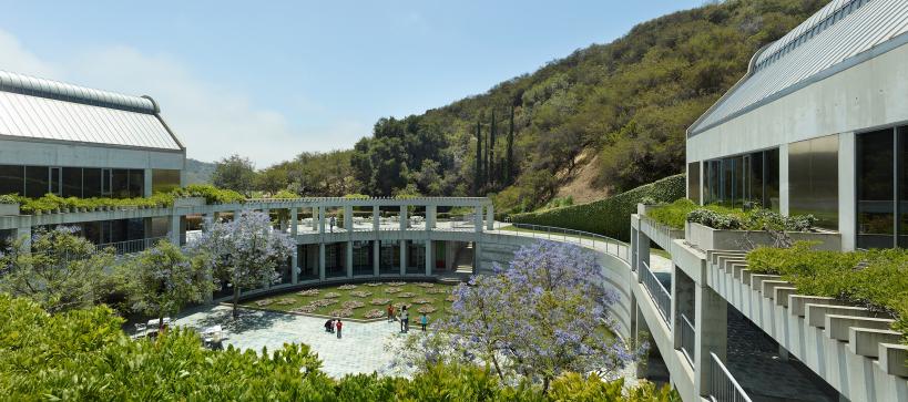 Image of Taper courtyard with visitors looking at the lily pond and mountains in the background