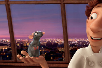 Still from the movie Ratatouille showing Linguini holding Remy in his apartment. The night sky and Eiffel Tower can be seen through the window.