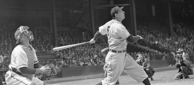 Baseball umpire, catcher and batter all looking up and toward the distance; the batter has just swung the bat