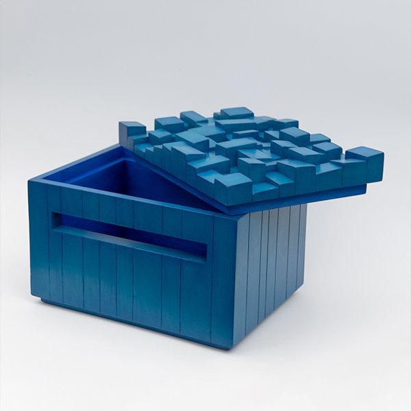Photo of the artwork. A blue box-like structure sits on a white background. The lid of the box is slightly off to show how it opens.