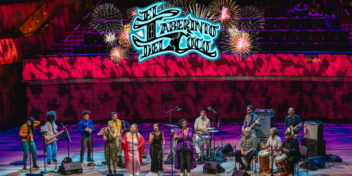 The band performs on a colorful stage with the name, El Laberinto del Coco in blue illuminated script above them.