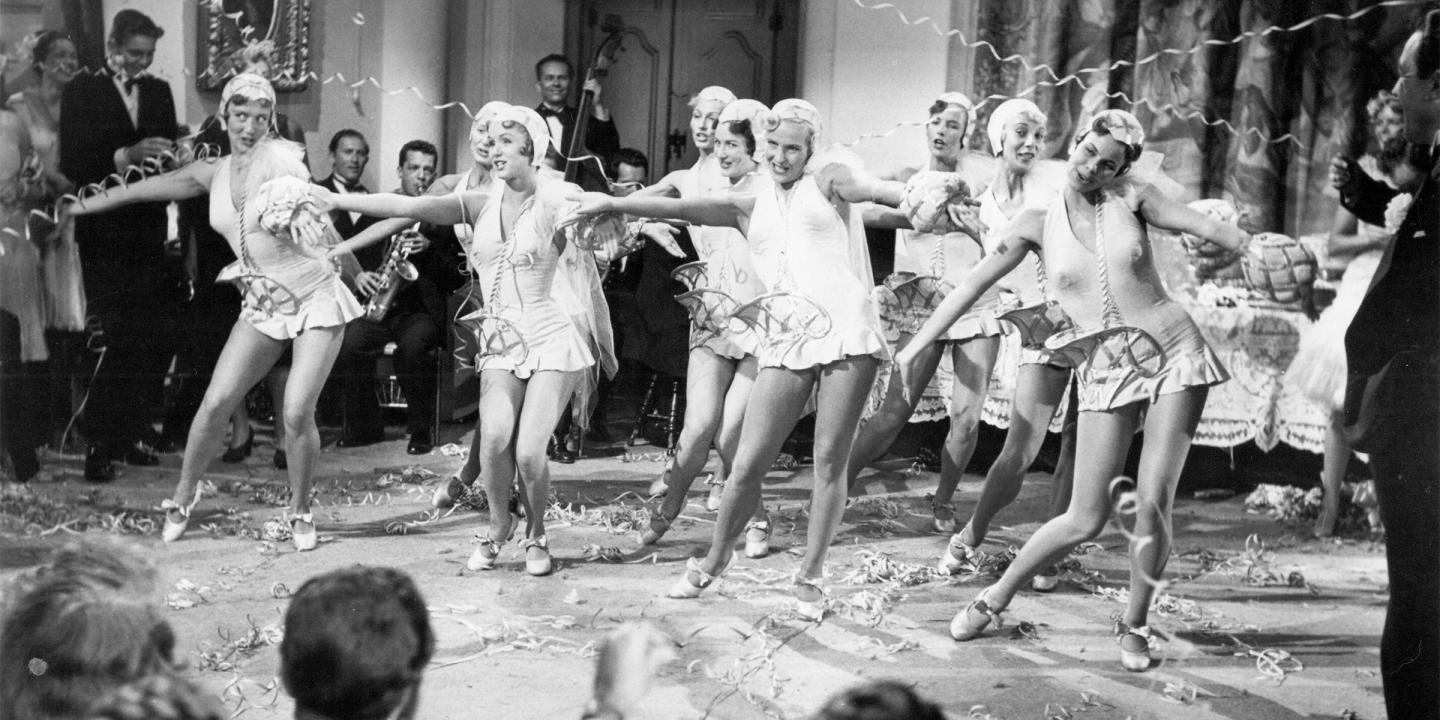 Still from the 1952 film Singin' in the Rain featuring Debbie Reynolds dancing with a troupe at a party.