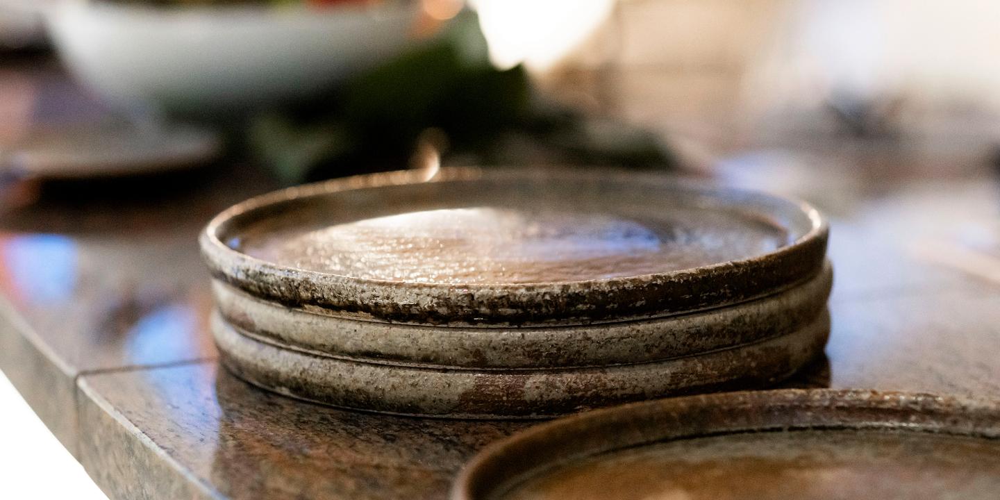 Plates made of pottery stacked on a kitchen bar.