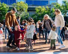 adults and children dancing outside