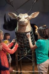 children with a sculpture of a deer with antlers