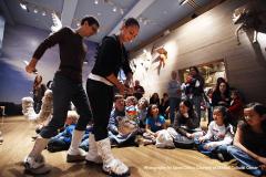 puppeteers acting in front of a group of children seated on the floor in front of Noah's Ark