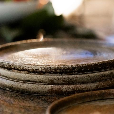 Plates made of pottery stacked on a kitchen bar.