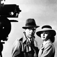Behind the scenes still from the film, Casablanca, showing a camera operator filming Rick and Ilsa making their farewell on the runway of the airport.