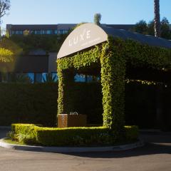 arched entryway to luxe hotel, covered in ivy