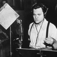 A newspaper photograph of Orson Welles performing his 1938 War of the Worlds broadcast in a radio studio standing in front of a microphone. Next to that is an illustration of a tripod alien from the novel shooting a laser at earth.