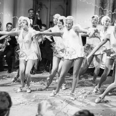 Still from the 1952 film Singin' in the Rain featuring Debbie Reynolds dancing with a troupe at a party.